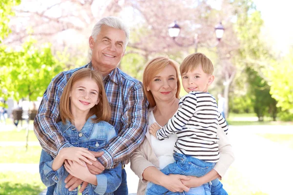 Niedliche glückliche Kinder mit Großeltern im Frühlingspark — Stockfoto