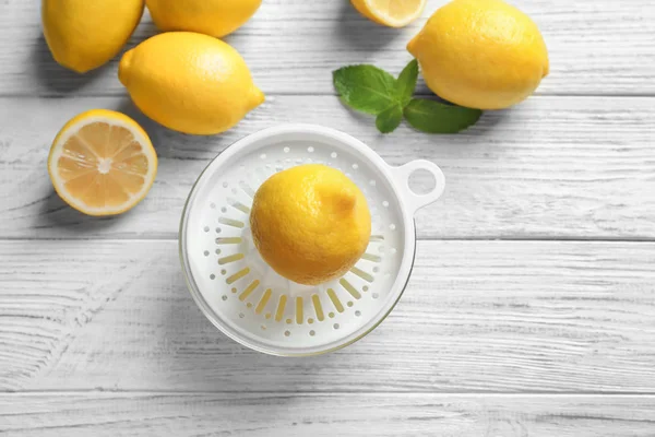 Lemons and plastic squeezer — Stock Photo, Image