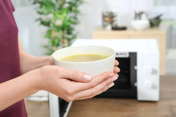 Kvinna anläggning skål med välsmakande soppa — Stockfoto