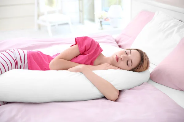 Frau schläft mit Körperkissen — Stockfoto