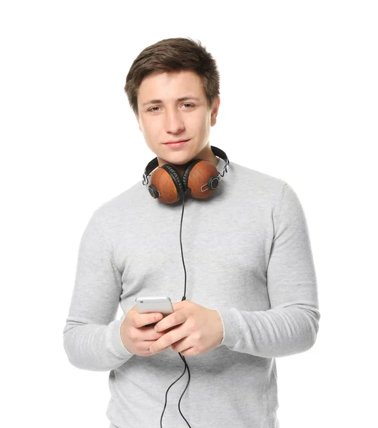 Roztomilý dospívající chlapec s mobilním telefonem a sluchátky na bílém pozadí — Stock fotografie
