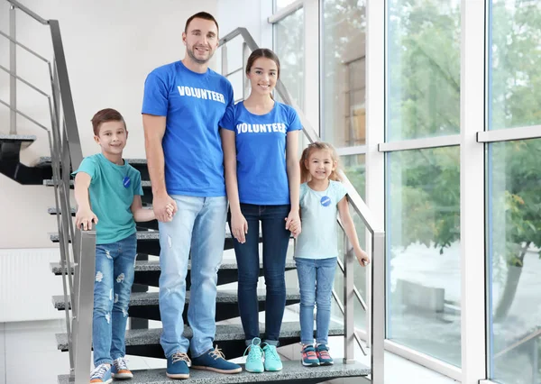 Happy relawan dan anak-anak berdiri di tangga di dalam ruangan — Stok Foto