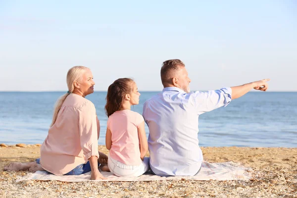 Ragazza carina con i nonni sulla spiaggia di mare — Foto Stock