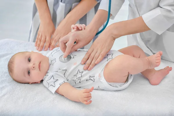 Médico examinando al bebé con estetoscopio en casa —  Fotos de Stock