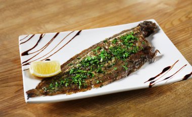 Plaka lezzetli kızarmış balık ve masada sos ile