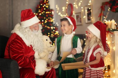 Güzel Noel dekorasyonu ile odada Noel babaya mektuplar gösterilen sevimli elf çocuklar