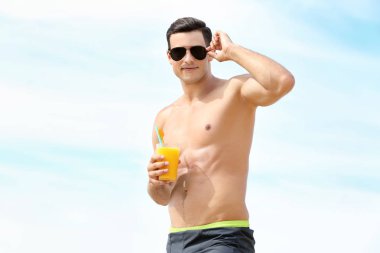 Deniz sahilinde içkiyle yakışıklı genç