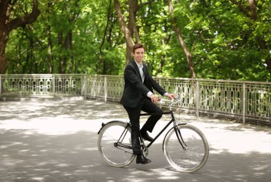 Genç yakışıklı işadamı güneşli günü açık havada bisiklet ile