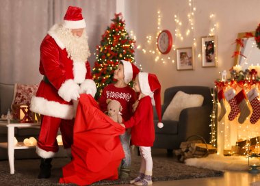 Oda güzel Noel süslemeleri ile şirin çocuklara gösterilen Santa sunar