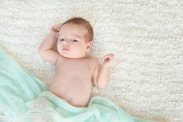 Carino piccolo bambino sdraiato su plaid morbido — Foto Stock