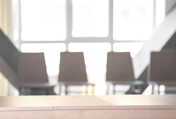 Empty wooden table and blurred chairs — Stock Photo, Image