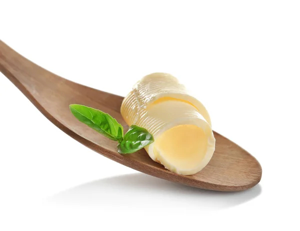 Houten lepel met heerlijke boter curl en basilicum — Stockfoto