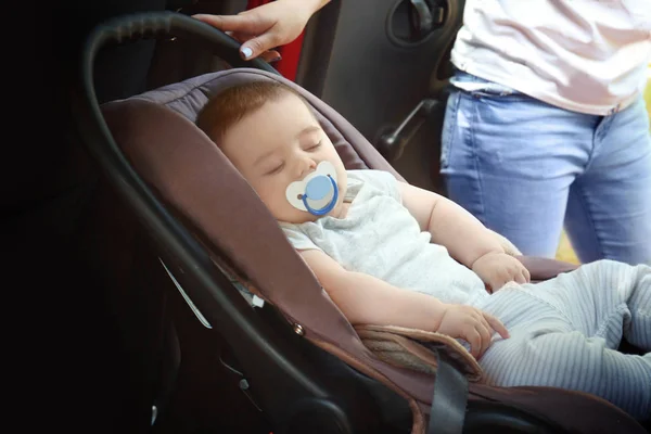 Mother with sleeping baby in child safety seat inside of car — Stock Photo, Image