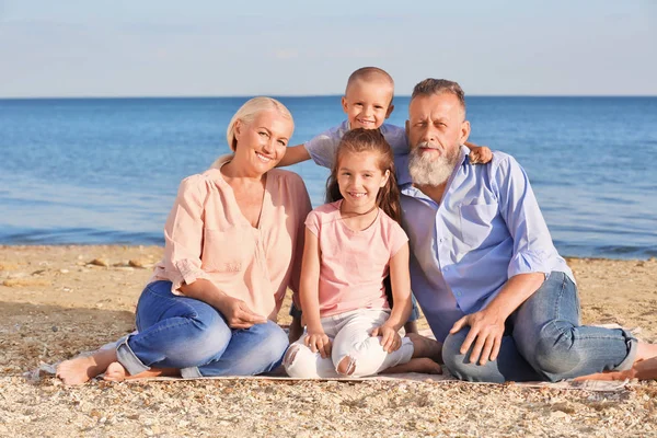 Schattige kinderen met grootouders op zee strand — Stockfoto