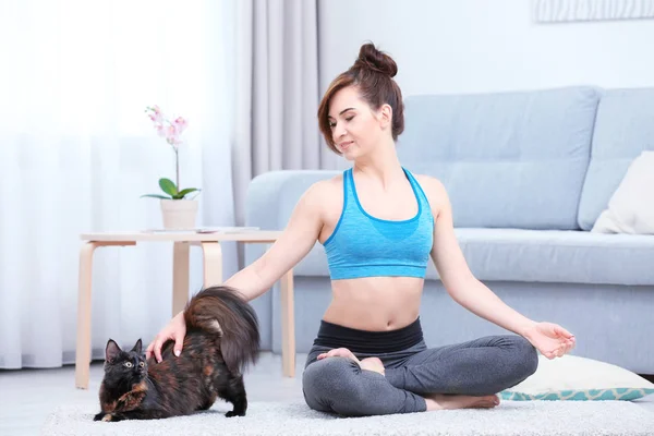 Mujer joven con gato practicando yoga —  Fotos de Stock