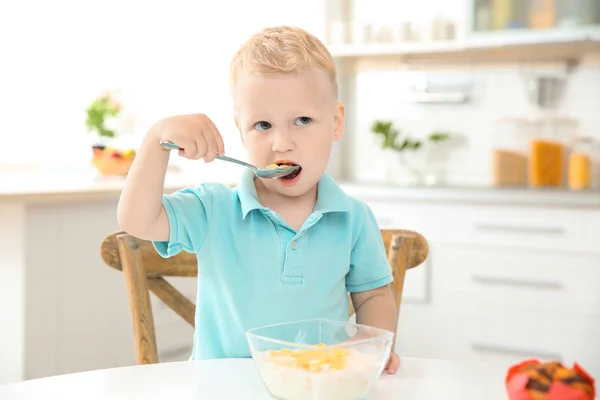 キッチンで大きなスプーンでシリアルを食べる愛らしい少年 — ストック写真