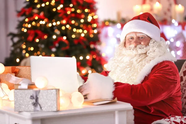 Santa claus met behulp van laptop — Stockfoto