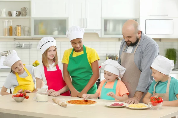 Группа детей и преподавателей на кухне во время уроков кулинарии — стоковое фото