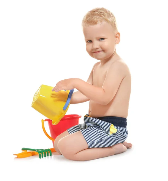 Ładny mały chłopiec w kąpielówki, bawi się zabawkami plaży na białym tle — Zdjęcie stockowe