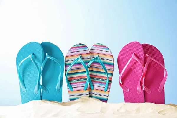 Colorful flip-flops on sand — Stock Photo, Image