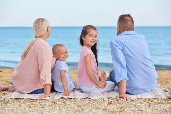 Милые дети с бабушкой и дедушкой на морском пляже — стоковое фото