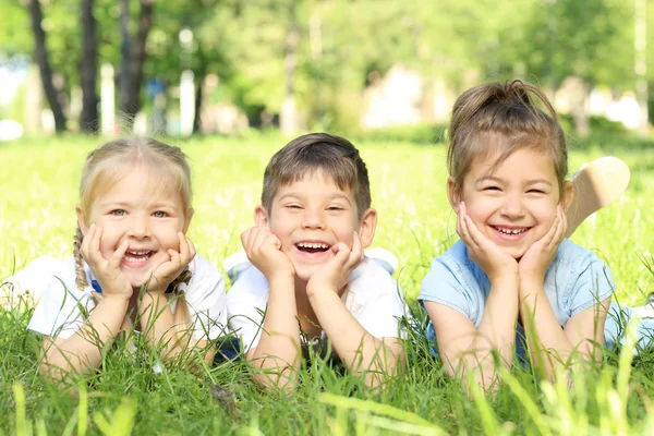 귀여운 어린 아이 들을 공원에서 푸른 잔디에 누워 — 스톡 사진