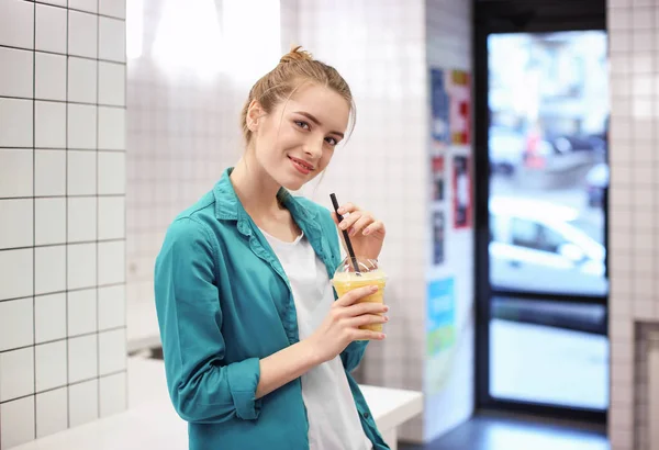 Giovane donna hipster sorridente che beve frullato in casa — Foto Stock