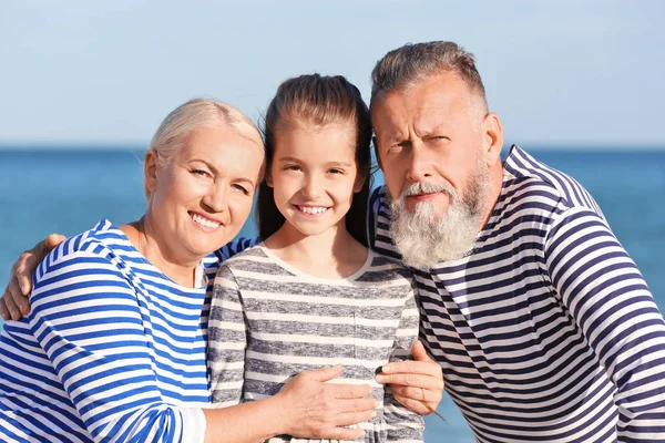 Милая девушка с бабушкой и дедушкой на морском пляже — стоковое фото
