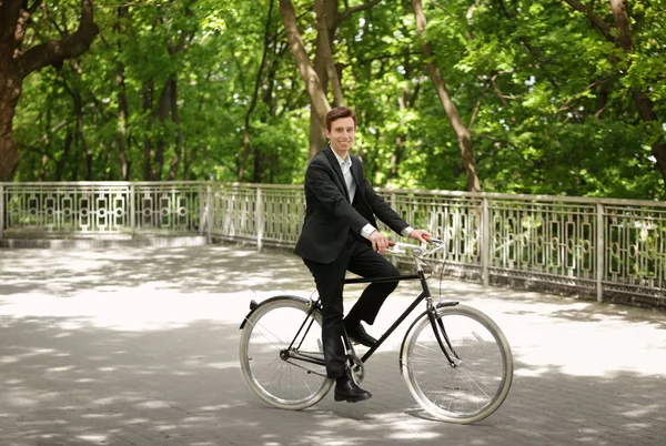 Genç yakışıklı işadamı güneşli günü açık havada bisiklet ile