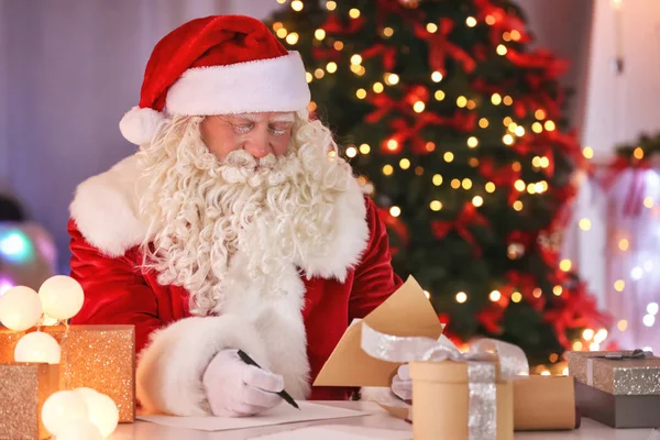 Weihnachtsmann arbeitet am Tisch — Stockfoto