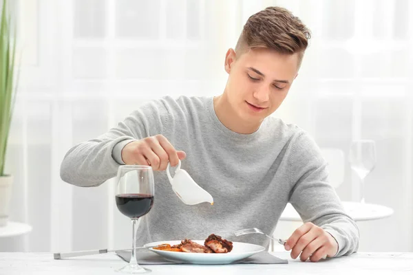 Young man eating delicious ribs