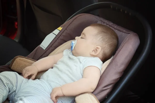 Bebê adorável com chupeta dormindo no assento de segurança infantil dentro do carro — Fotografia de Stock