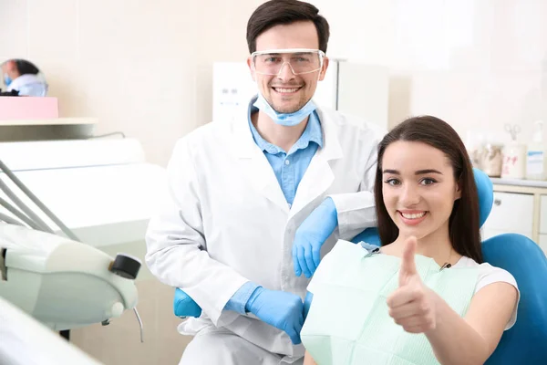 Szczęśliwa młoda kobieta i mężczyzna dentysta po leczeniu w klinice — Zdjęcie stockowe