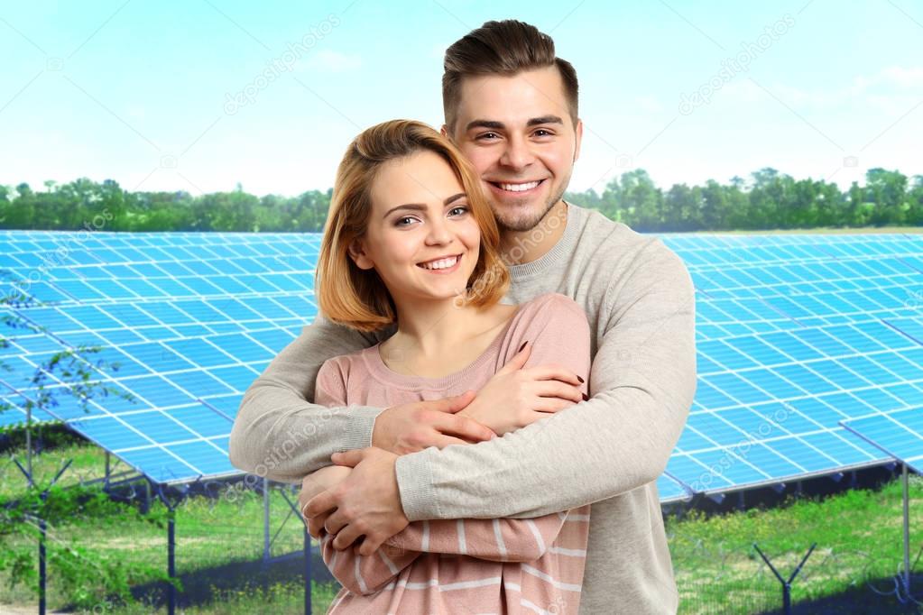 Young couple and solar panels on background