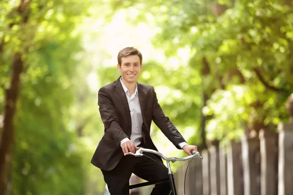 Genç yakışıklı işadamı güneşli günü açık havada bisiklet ile