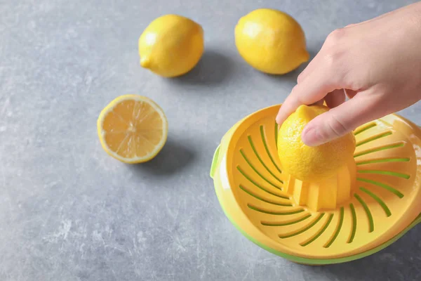 Man's hand juicing lemon with plastic squeezer — Stock Photo, Image