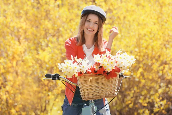 Young girl with bicycle and basket of flowers — Stock Photo, Image