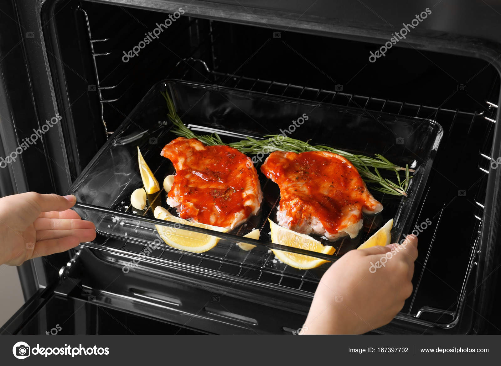 Woman putting baking tray Stock Photo by ©belchonock 167397702