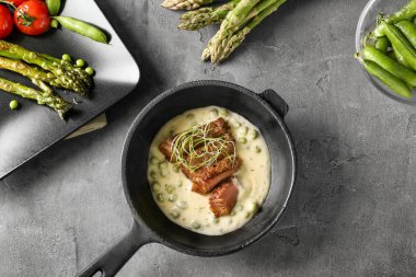 Kızartma tavası dilimlenmiş biftek ve gri arka plan üzerine sos ile