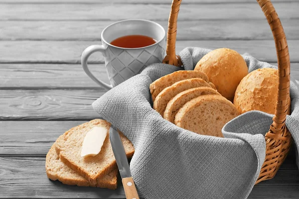 Beautiful composition with delicious bread and cup of tea on wooden table — Stock Photo, Image