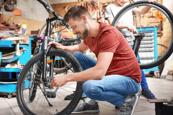 Dad and son fixing bicycles — Stock Photo, Image