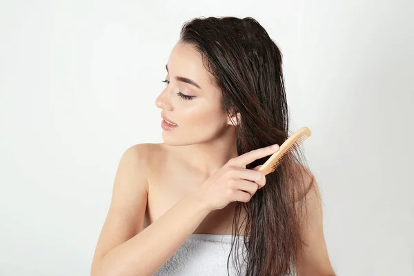 Mladá žena česání vlasy — Stock fotografie