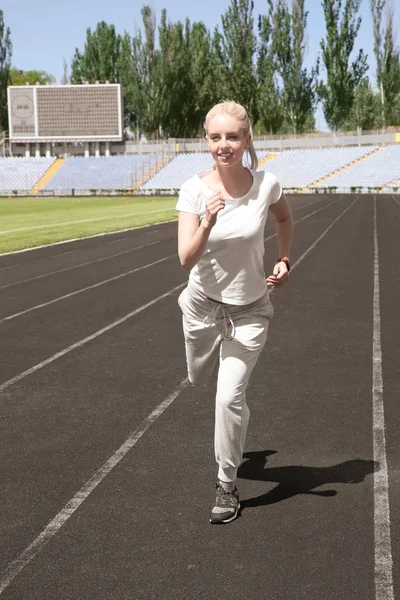 Fiatal gyönyörű nő futás-on stadion — Stock Fotó