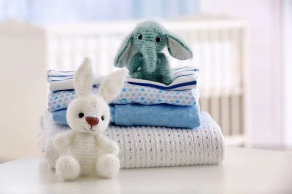 Carino giocattoli a maglia e vestiti per bambini sulla tavola — Foto Stock