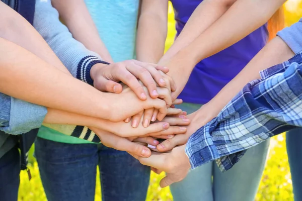 若い人たちは、一緒に屋外の手を置きます。ボランティアの概念 — ストック写真