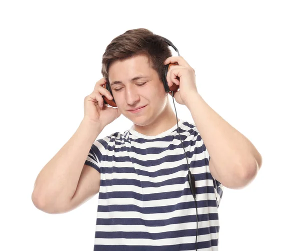 Bonito adolescente com fones de ouvido ouvindo música no fundo branco — Fotografia de Stock