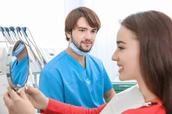 Dentista e paciente feliz olhando no espelho após o tratamento — Fotografia de Stock