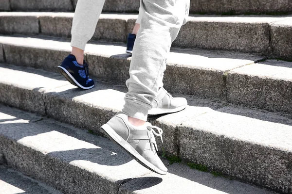 Спортивная пара бежит вверх по каменной лестнице — стоковое фото