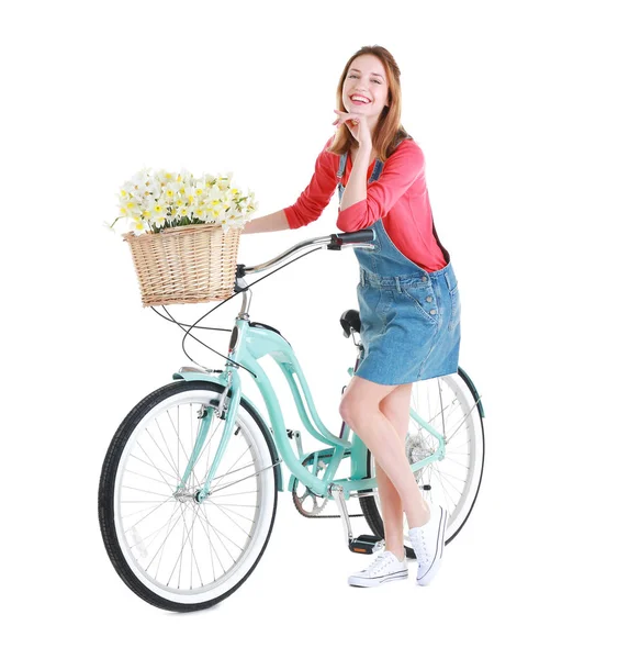 Ung flicka med cykel och korg med blommor — Stockfoto