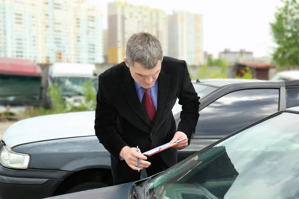 Insurance man checking broken car — Stock Photo, Image